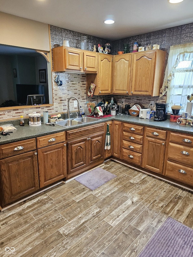 kitchen with backsplash, sink, and wood-type flooring