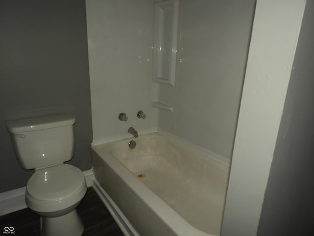 bathroom with hardwood / wood-style flooring, shower / bathtub combination, and toilet