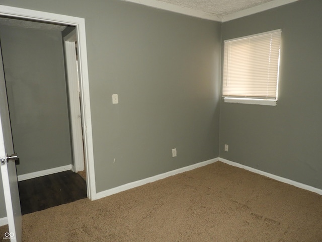 carpeted spare room with a textured ceiling