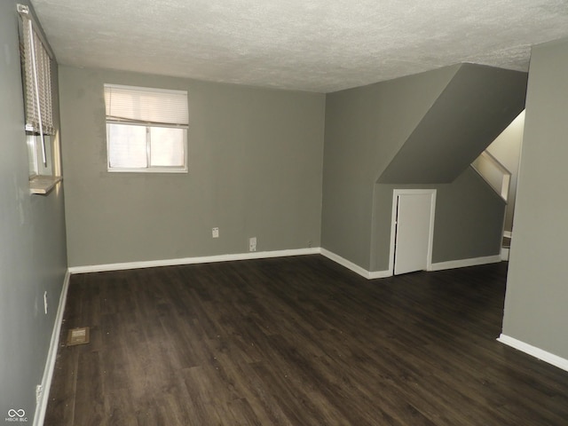 interior space featuring a textured ceiling and dark wood-type flooring