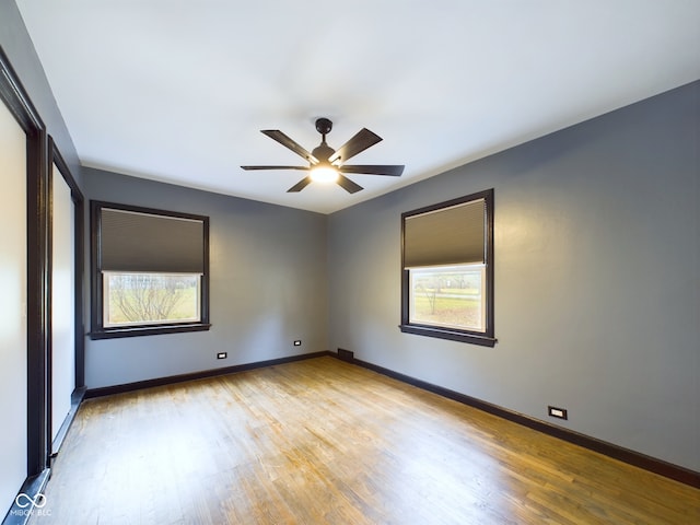 empty room with ceiling fan and light hardwood / wood-style flooring