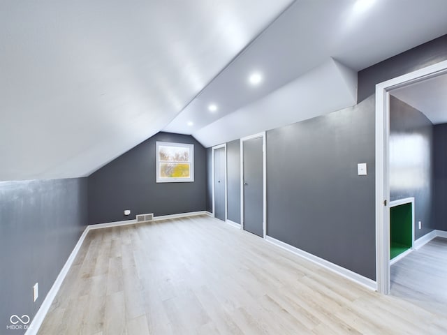 bonus room featuring light wood-type flooring and lofted ceiling