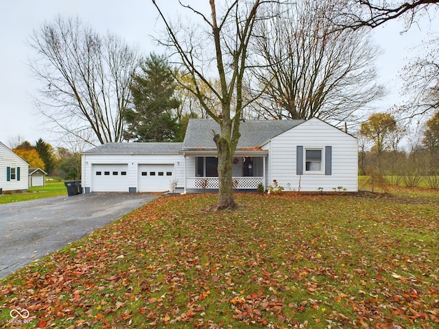 view of front facade with a sunroom, a front yard, and a garage