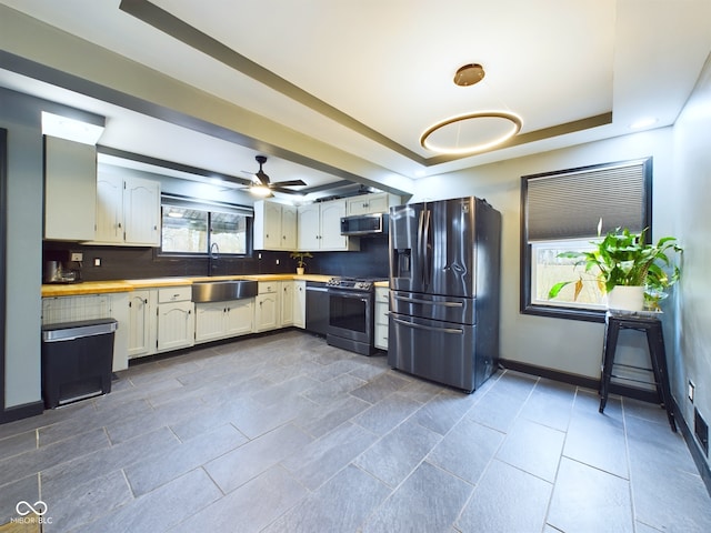 kitchen featuring a healthy amount of sunlight, sink, stainless steel appliances, and tasteful backsplash