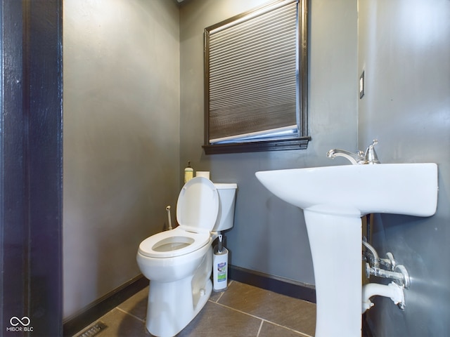 bathroom with tile patterned flooring, toilet, and sink