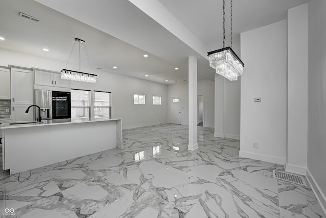 unfurnished living room with a notable chandelier and sink