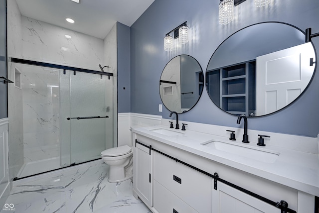 bathroom featuring vanity, toilet, and a shower with shower door