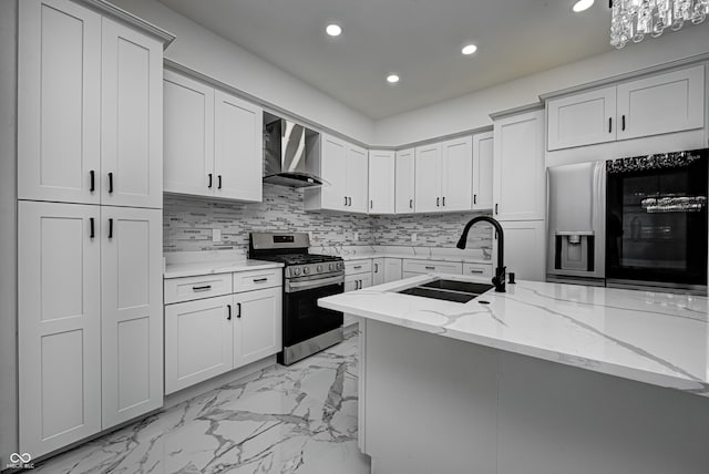 kitchen with black fridge, sink, wall chimney exhaust hood, light stone countertops, and stainless steel range oven