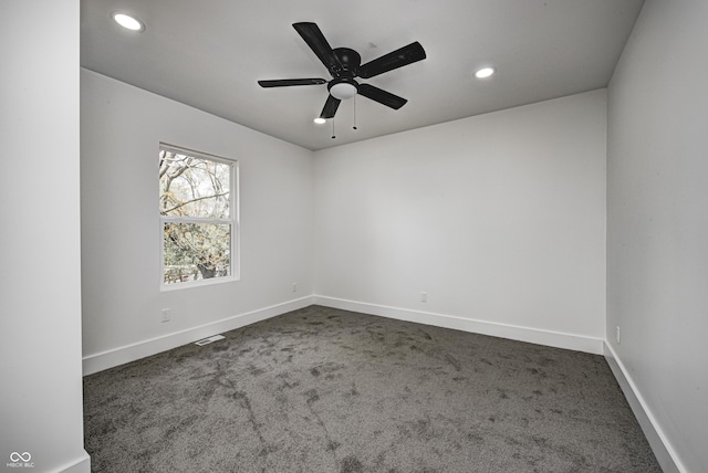 carpeted spare room featuring ceiling fan