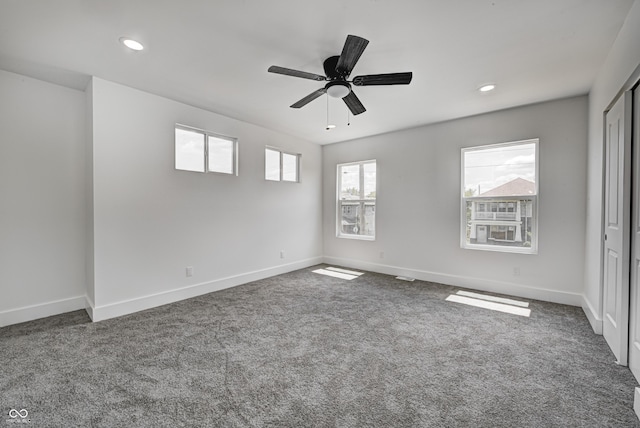 carpeted spare room featuring ceiling fan