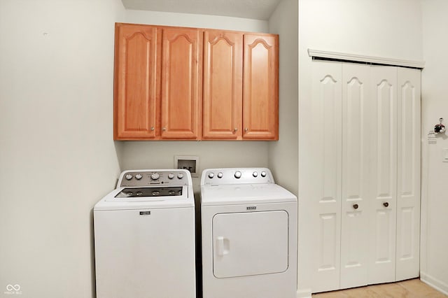 washroom featuring separate washer and dryer and cabinets