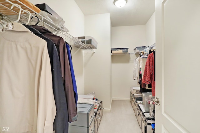 walk in closet featuring light carpet