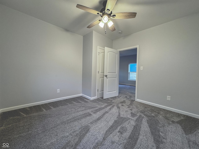 unfurnished room featuring ceiling fan and dark carpet