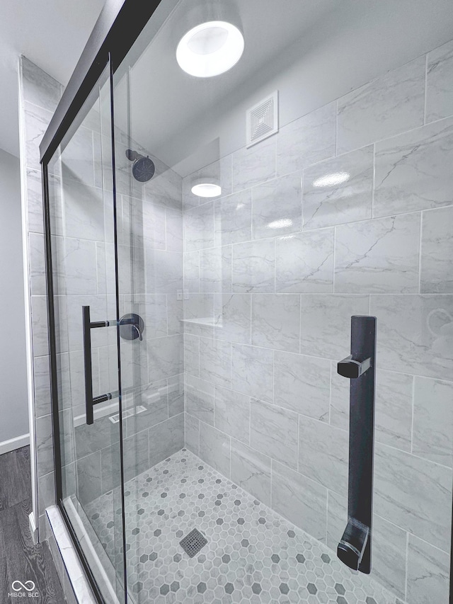 bathroom featuring a shower with shower door