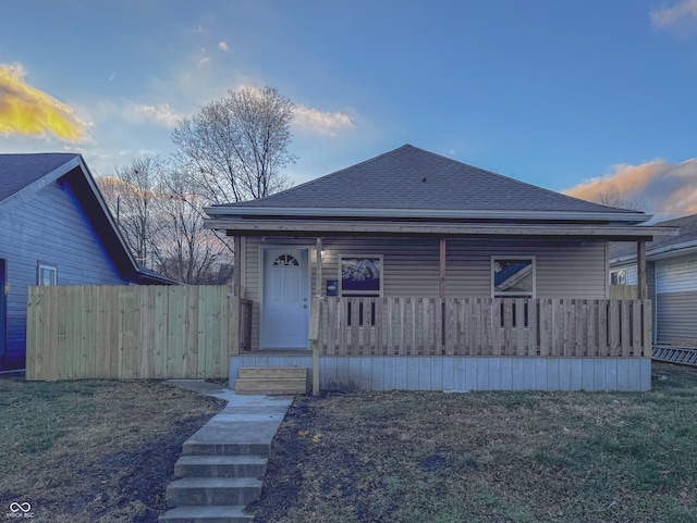 bungalow-style house featuring a porch and a yard