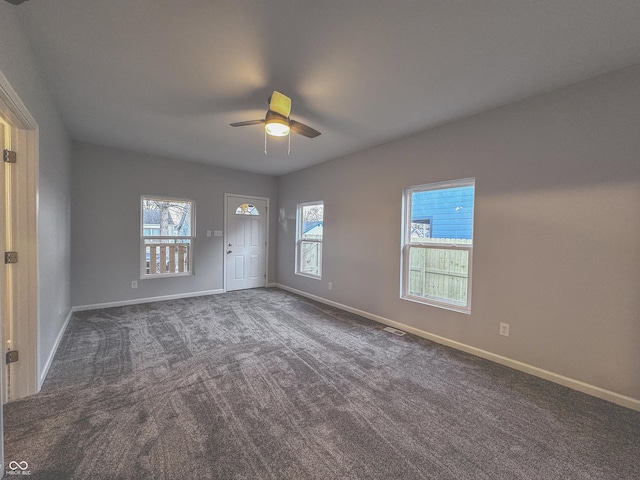 carpeted empty room with plenty of natural light and ceiling fan