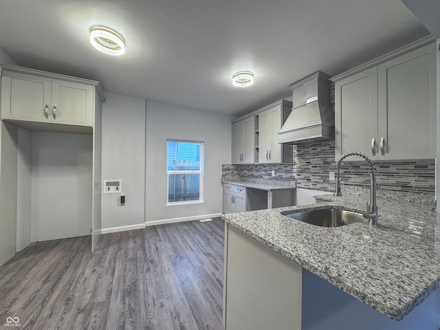 kitchen with sink, stone countertops, dark wood-type flooring, and custom exhaust hood