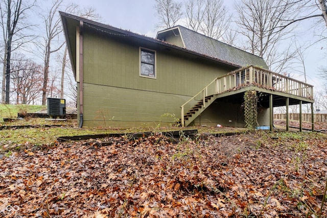 view of side of property featuring central air condition unit and a wooden deck