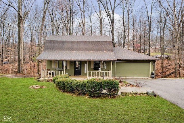 view of front of property featuring a garage, covered porch, and a front yard