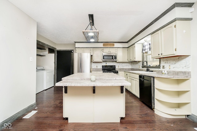 kitchen with washer and clothes dryer, black appliances, sink, hanging light fixtures, and a kitchen island