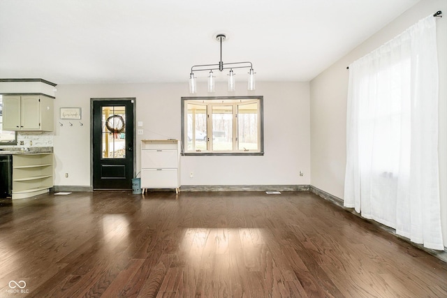 unfurnished dining area featuring dark wood-type flooring