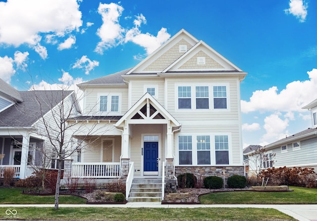 craftsman-style home with covered porch and a front yard