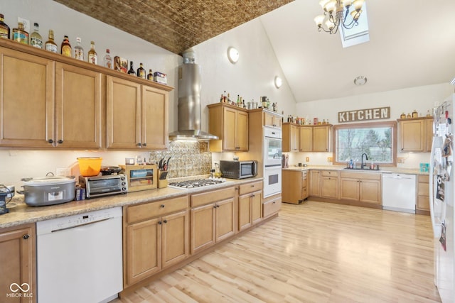 kitchen featuring light wood-type flooring, white appliances, sink, and wall chimney range hood