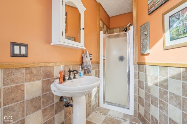 bathroom featuring walk in shower, tile walls, and a textured ceiling