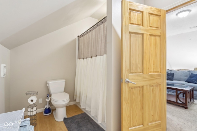 bathroom featuring hardwood / wood-style flooring, lofted ceiling, and toilet