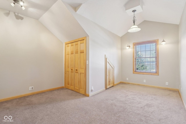 additional living space featuring vaulted ceiling and light carpet