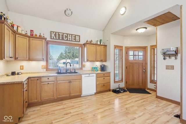 kitchen featuring dishwasher, lofted ceiling, sink, and light hardwood / wood-style flooring