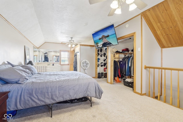 carpeted bedroom featuring lofted ceiling, a walk in closet, and ceiling fan