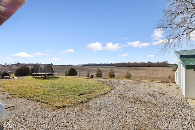 view of yard with a trampoline and a rural view