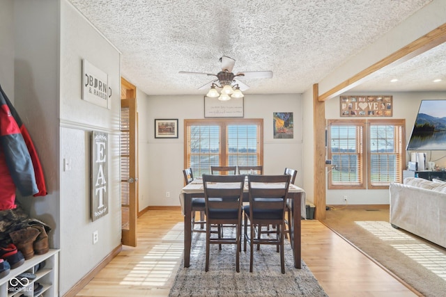 dining room with ceiling fan, a textured ceiling, and light wood-type flooring