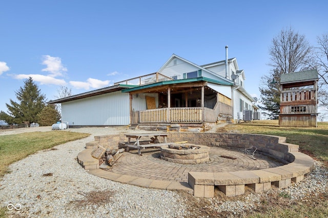 view of front of home featuring central AC unit and a fire pit