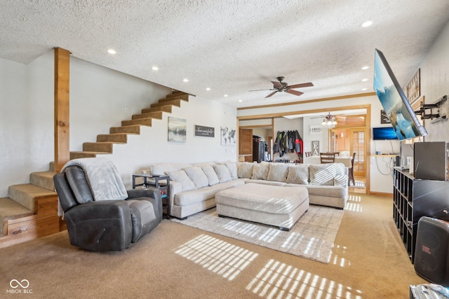 living room with ceiling fan, light colored carpet, and a textured ceiling