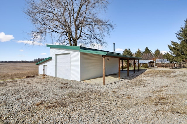 view of outdoor structure with a carport and a garage