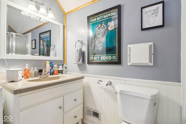 bathroom featuring vanity, toilet, and an enclosed shower