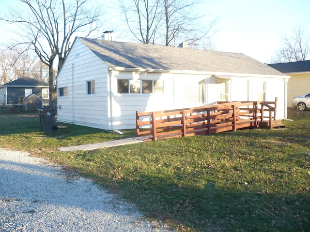 exterior space with a wooden deck and a front yard