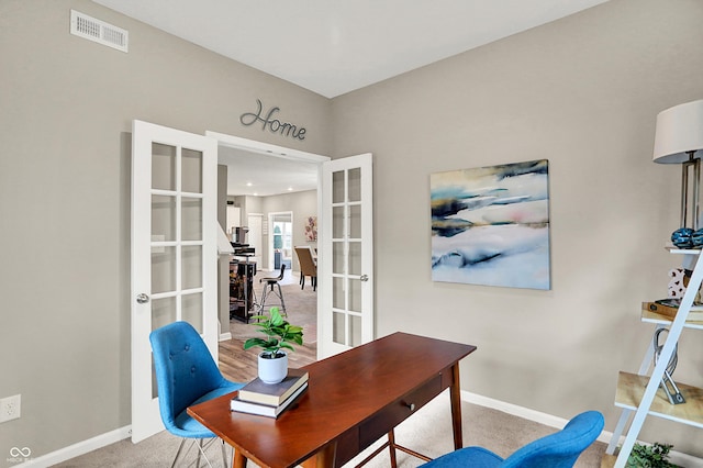 carpeted home office featuring french doors