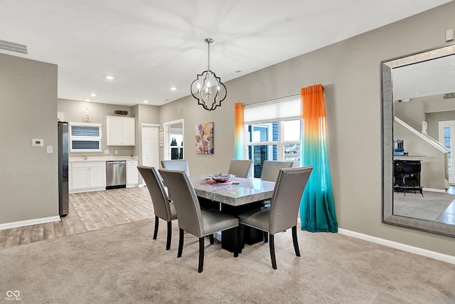 carpeted dining room featuring a chandelier