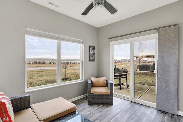 sitting room with ceiling fan, plenty of natural light, and light wood-type flooring