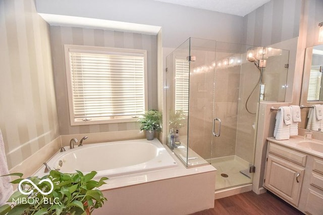 bathroom with hardwood / wood-style floors, plenty of natural light, shower with separate bathtub, and vanity