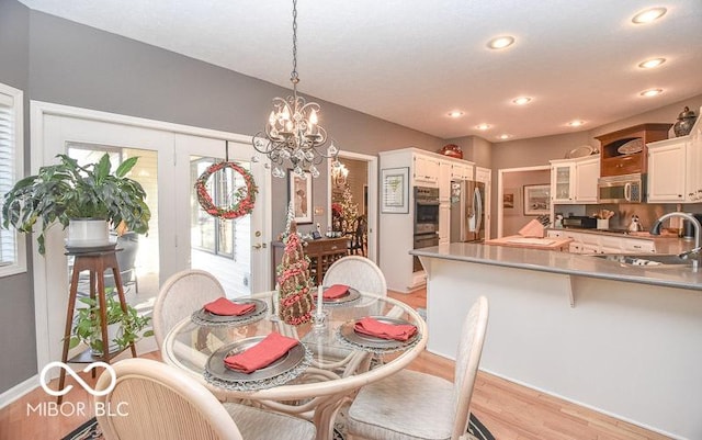 dining room featuring french doors, light hardwood / wood-style floors, plenty of natural light, and sink