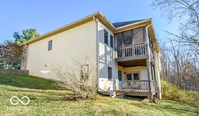 rear view of property with a yard, a deck, and a sunroom