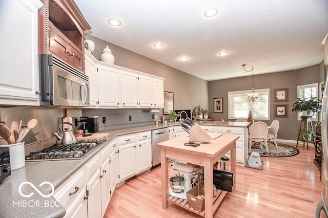 kitchen featuring pendant lighting, white cabinetry, and stainless steel appliances