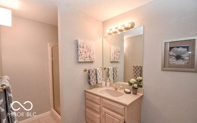 bathroom featuring tile patterned floors, vanity, and a shower with shower door