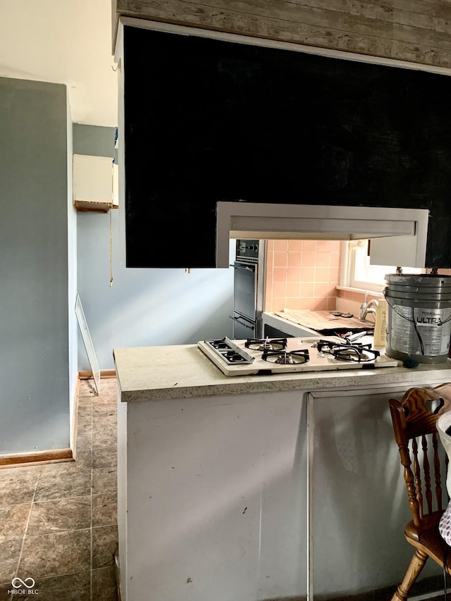 kitchen featuring decorative backsplash and white gas stovetop