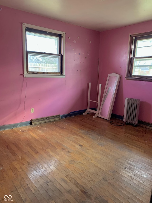 spare room featuring light hardwood / wood-style floors and radiator