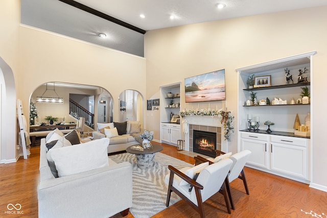 living room featuring light wood-type flooring, a fireplace, and high vaulted ceiling